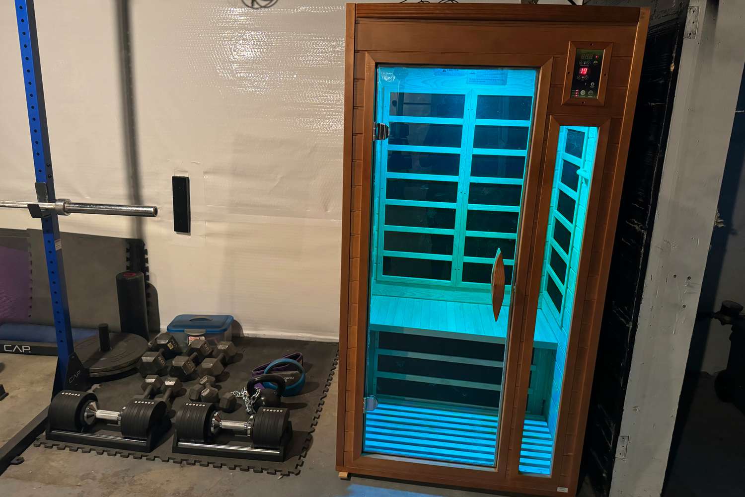 The Dynamic Barcelona 1 to 2 Person Hemlock Wood Low EMF FAR Infrared Sauna lit up in a basement